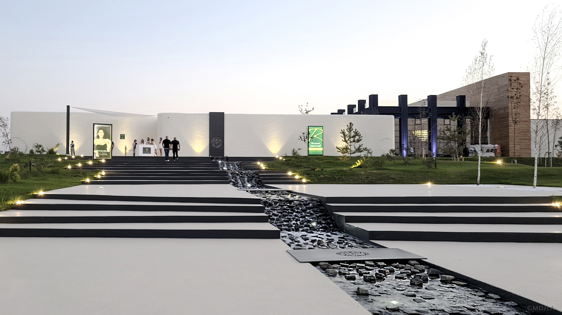 Acces monumental cu trepte și râu ornamental din piatră neagră, direcționând vizitatorii spre intrarea principală Ramatuelle